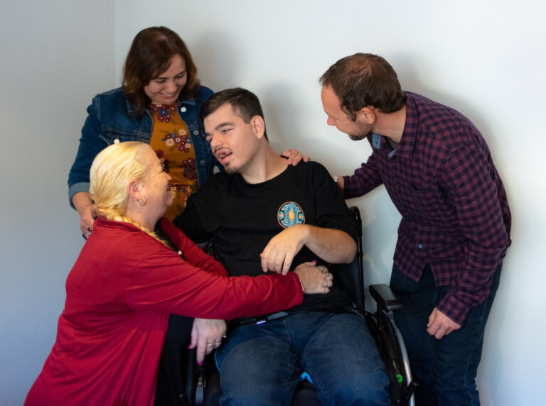 Josh Man in wheelchair surrounded by loving family
